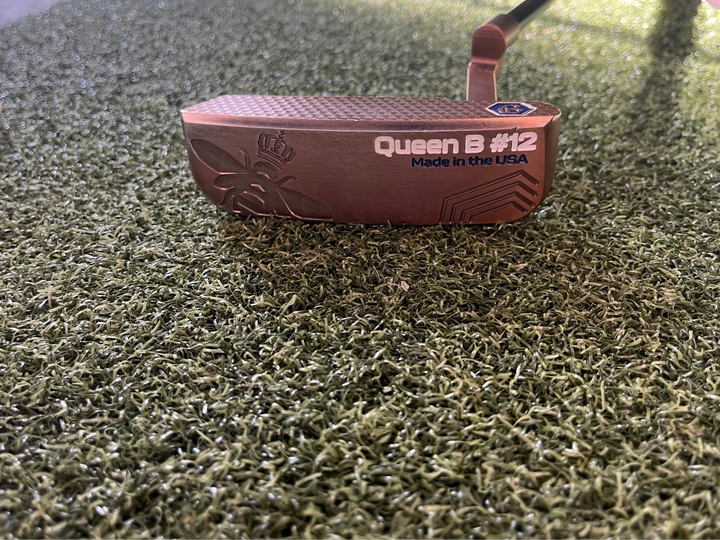 Bettinardi Queen B #12 putter golf club with copper finish on artificial turf