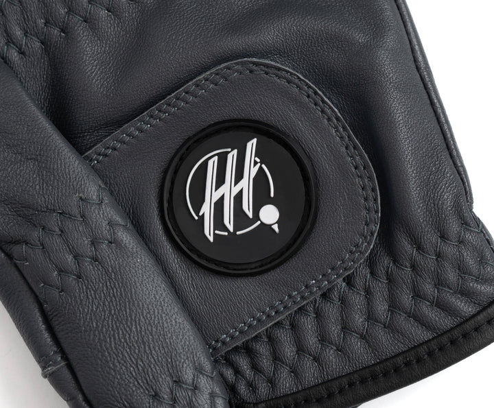 Close-up of black premium golf glove for lefties with detailed stitching and logo patch