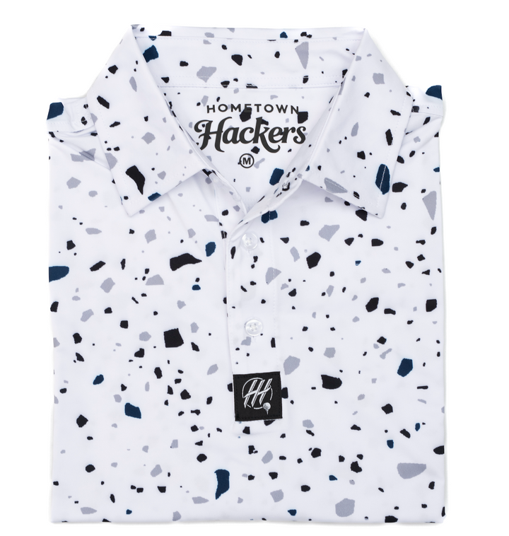 Hometown Hackers premium golf polo with white base and black gray scattered pattern folded neatly