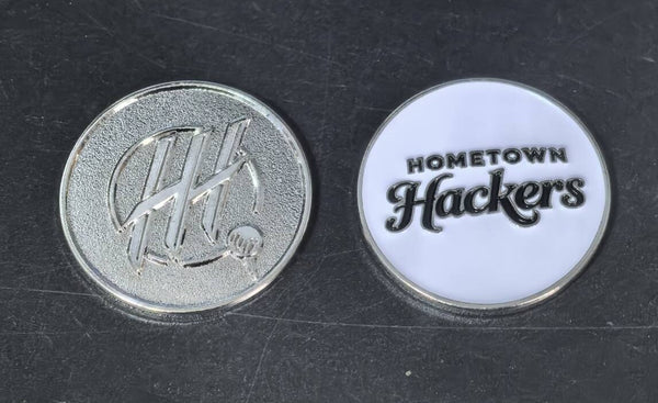Set of premium golf ball markers featuring Hometown Hackers logo on silver and white backgrounds