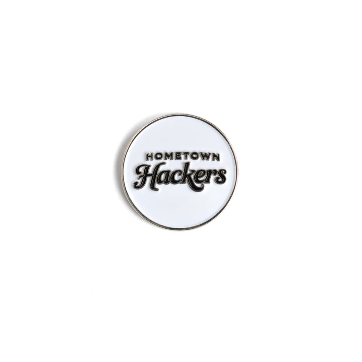 White and black Hometown Hackers premium golf ball markers with clear logo design