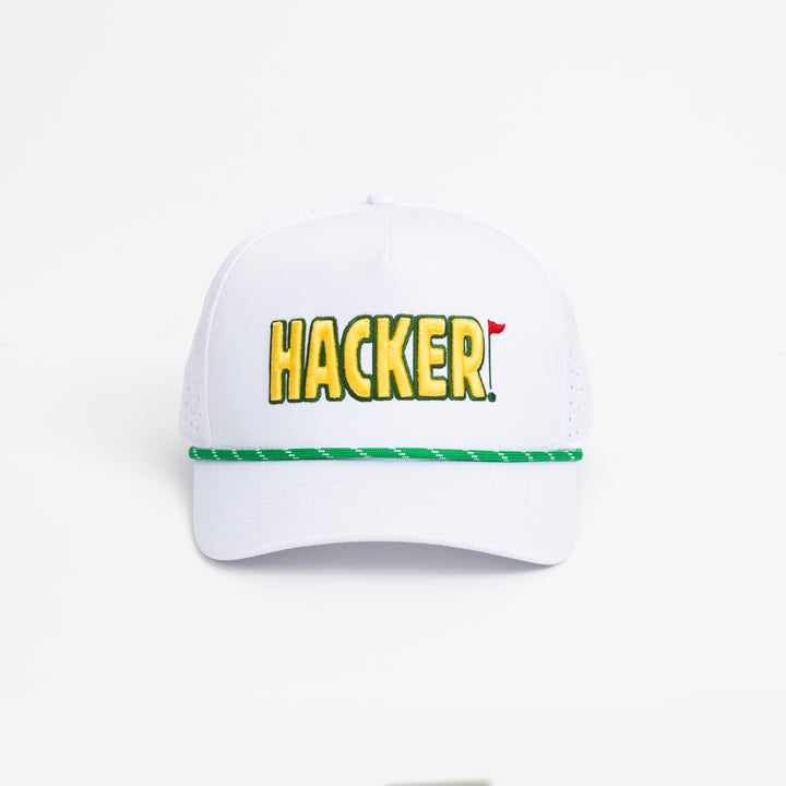 White premium golf hat with yellow HACKER embroidery and green striped trim across the brim